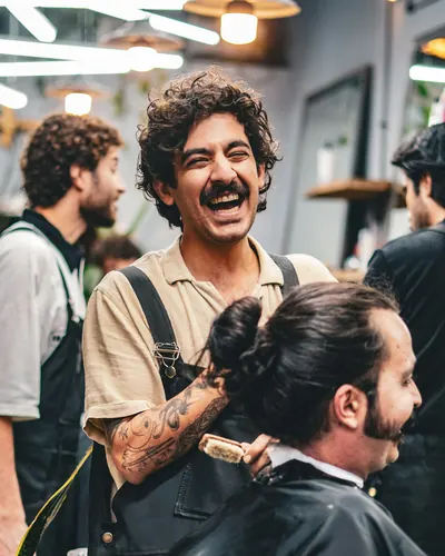 Barber laughing while cutting a client's hair