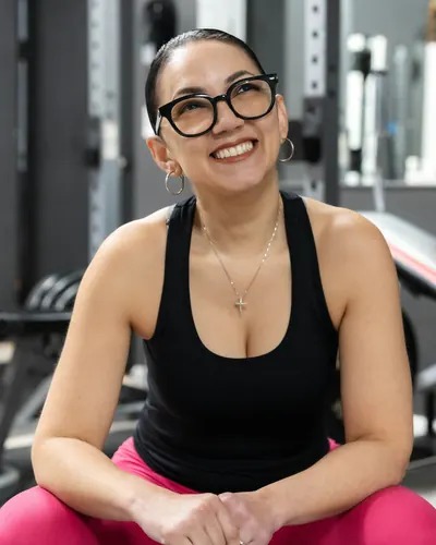 Fitness coach smiling in her gym