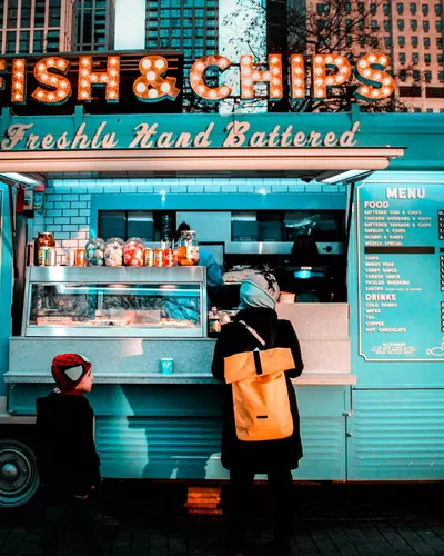 Owner at the window of a teal food truck